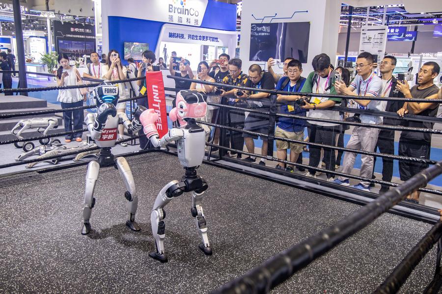 Jornalistas e convidados assistem a uma luta de boxe de robôs no estande da Unitree, no local da Exposição Mundial da Indústria Inteligente 2025, em Chongqing, sudoeste da China, em 4 de setembro de 2025. (Xinhua/Tang Yi)