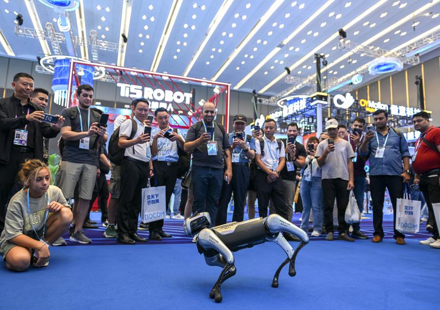 Visitantes assistem a uma apresentação de um cão robô no estande da MagicLab Robotics Technology Co., Ltd. na Zona de Robôs de Serviço durante a 138ª edição da Feira de Importação e Exportação da China (Feira de Cantão) em Guangzhou, Província de Guangdong, no sul da China, em 15 de outubro de 2025. (Xinhua/Xiao Ennan)