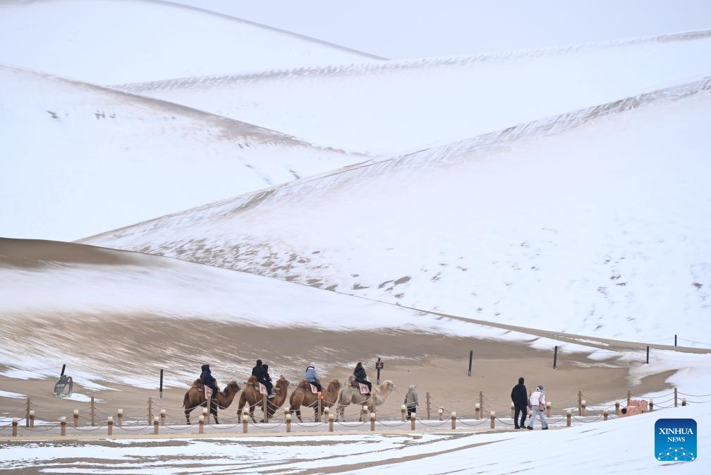 Neve muda paisagem da área cênica da Montanha Mingsha e do Lago da Lua Crescente na Cidade de Dunhuang