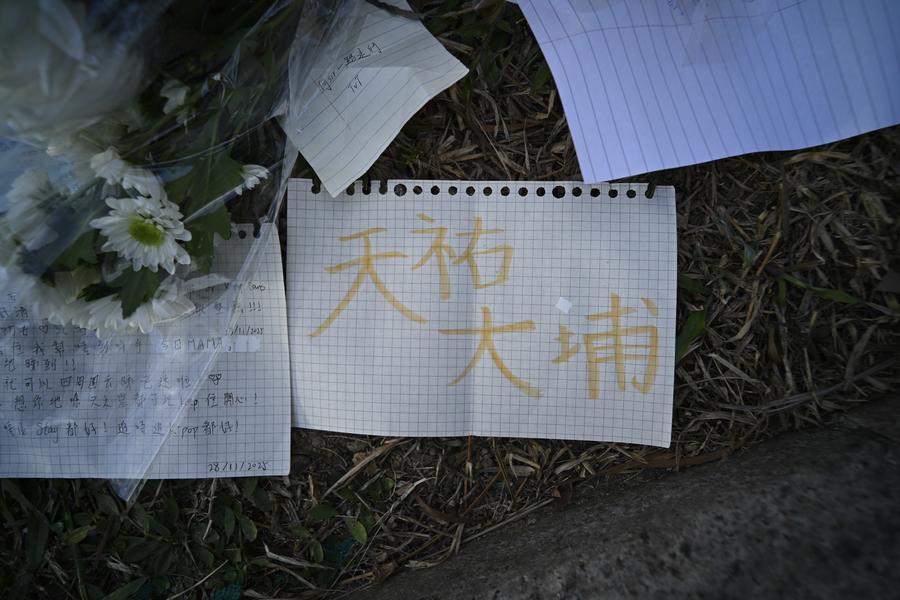 Esta foto tirada em 29 de novembro de 2025 mostra flores e bilhetes colocados perto do local do incêndio em um prédio residencial em Tai Po, Hong Kong, sul da China. (Xinhua/Wang Shen)