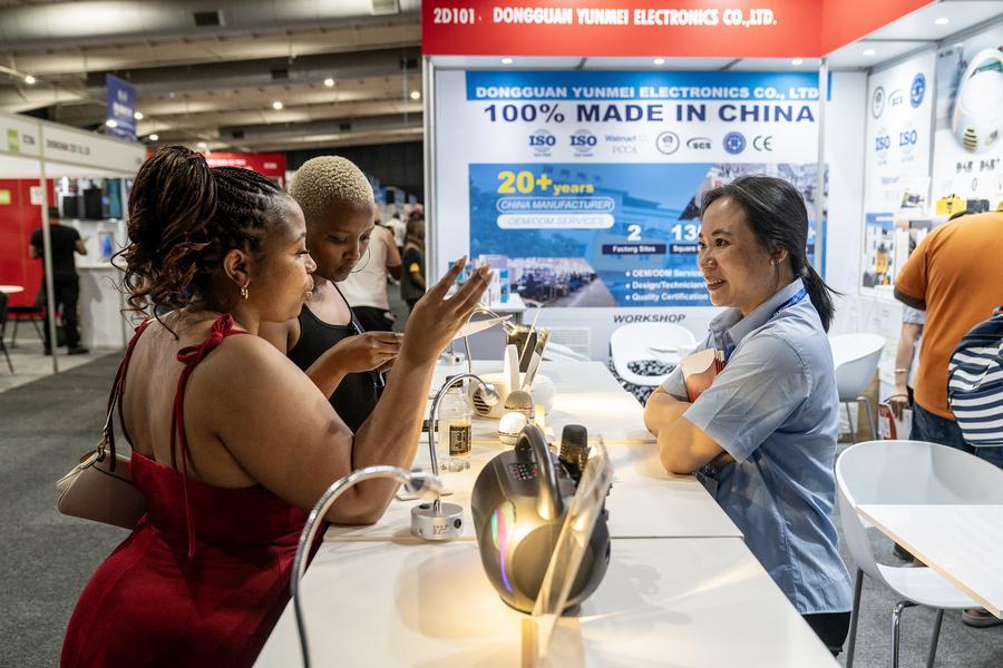 Visitantes conversam com expositora (à direita) na nona Feira Comercial China-África do Sul, em Joanesburgo, África do Sul, em 23 de setembro de 2025. (Foto de Shiraaz Mohamed/Xinhua)