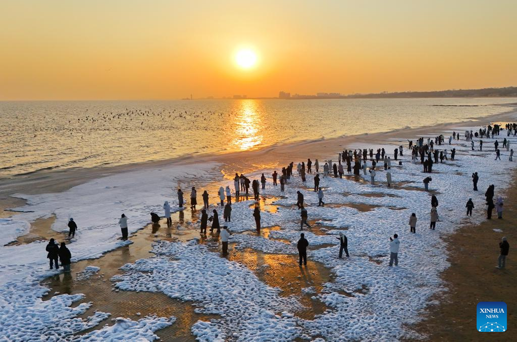 Turistas visitam praia coberta de gelo marinho em Hebei, norte da China