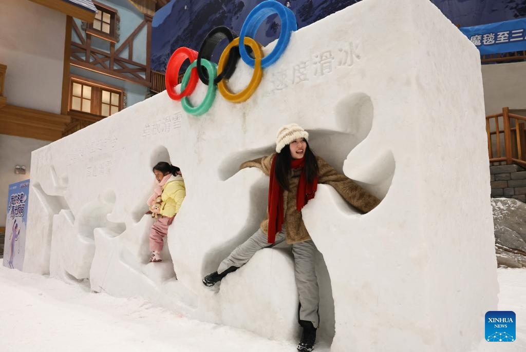 Turistas se divertem no parque temático coberto de gelo e neve em Shanghai